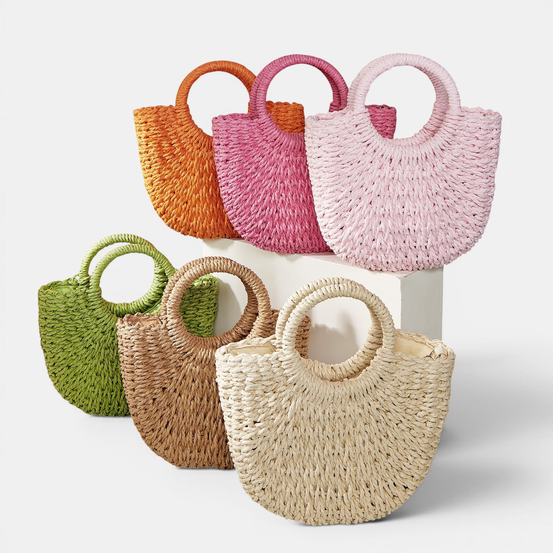 ZOFIA ATELIER Anna beach crossbody bag in woven paper with round handles, available in multiple colors.