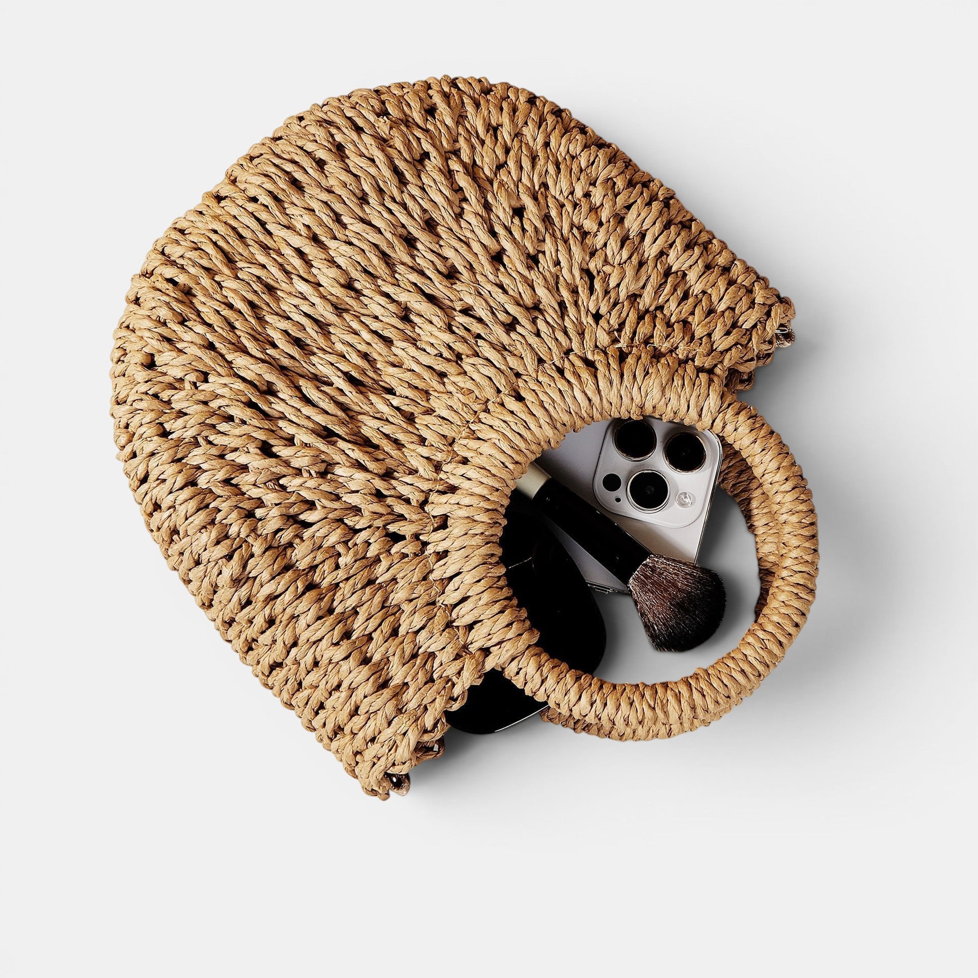 ZOFIA ATELIER ANNA crossbody bag made of woven paper in a natural straw color with a round handle. Holds a phone and makeup brush.