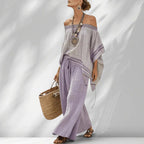 ZOFIA ATELIER BARBARA: Light grey off-shoulder top with purple trim and lavender wide-leg pants. Beach lounge set.