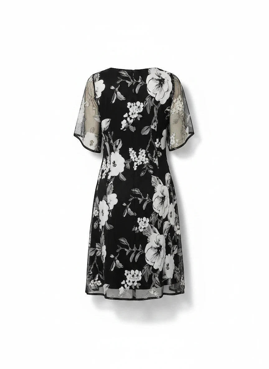 ZOFIA ATELIER black chiffon dress with white floral print, A-line skirt, and sheer flutter sleeves.