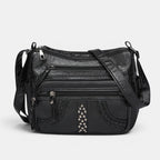 ZOFIA ATELIER black multi-layer PU crossbody bag with braided trim and stud embellishments.