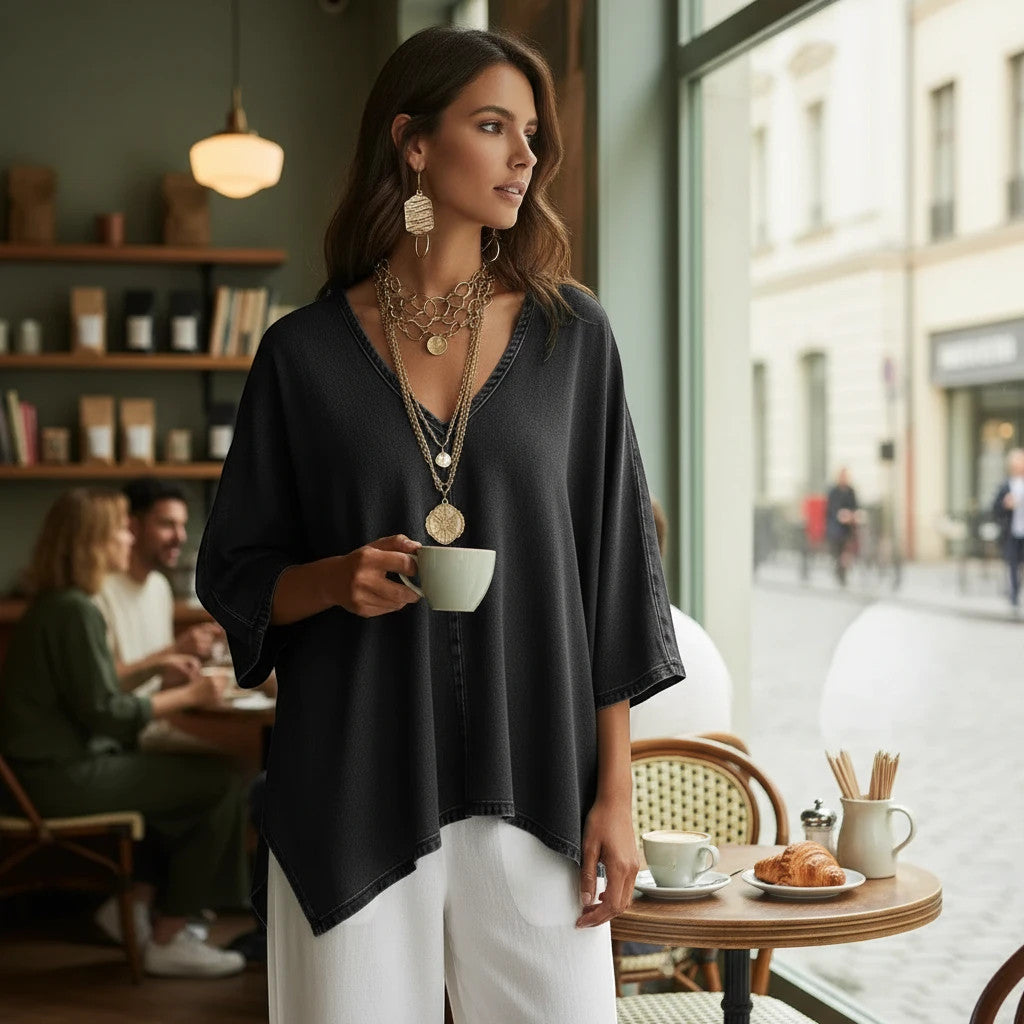 ZOFIA ATELIER black washed-out denim tunic blouse with V-neck and batwing sleeves, worn by a woman holding a coffee cup.