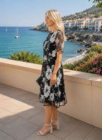 ZOFIA ATELIER black chiffon dress with white floral print, A-line skirt, and sheer flutter sleeves.