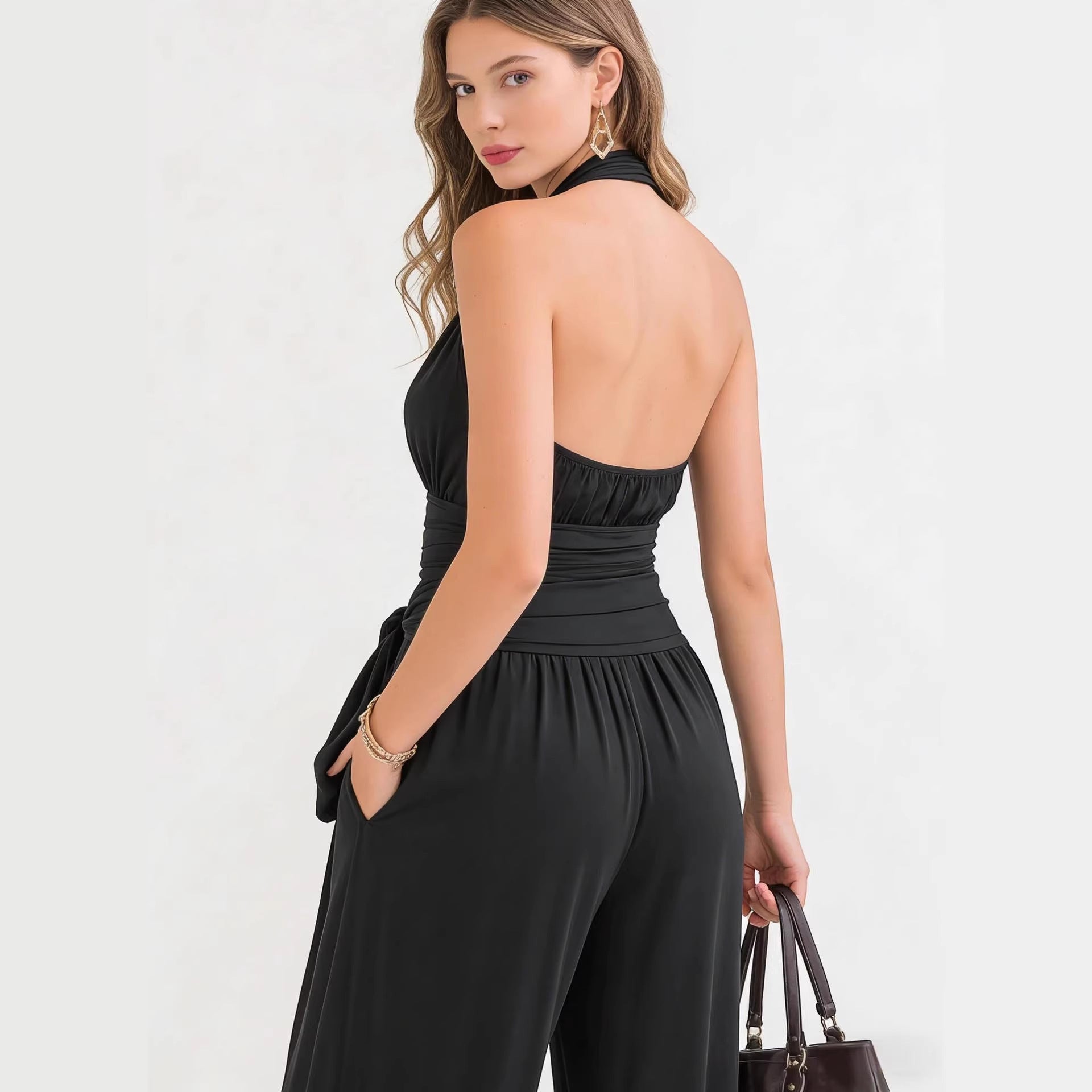 ZOFIA ATELIER black halter-neck sleeveless wide-leg jumpsuit with a belted waist and pockets.