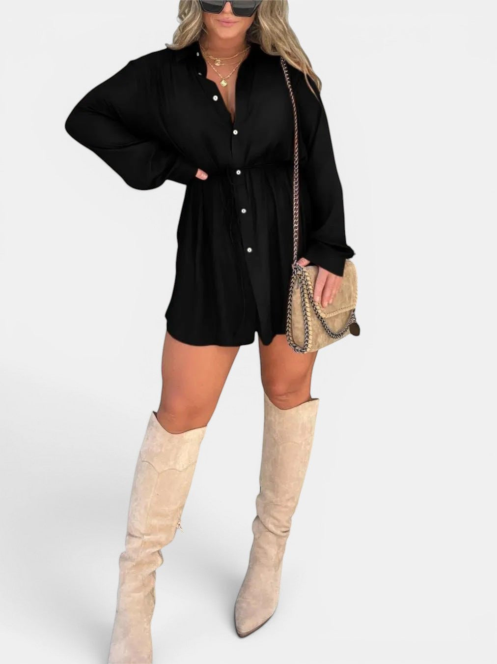 ZOFIA ATELIER black long sleeve button front jumpsuit with lace-up detail and a tie waist, paired with beige boots and a crossbody bag.
