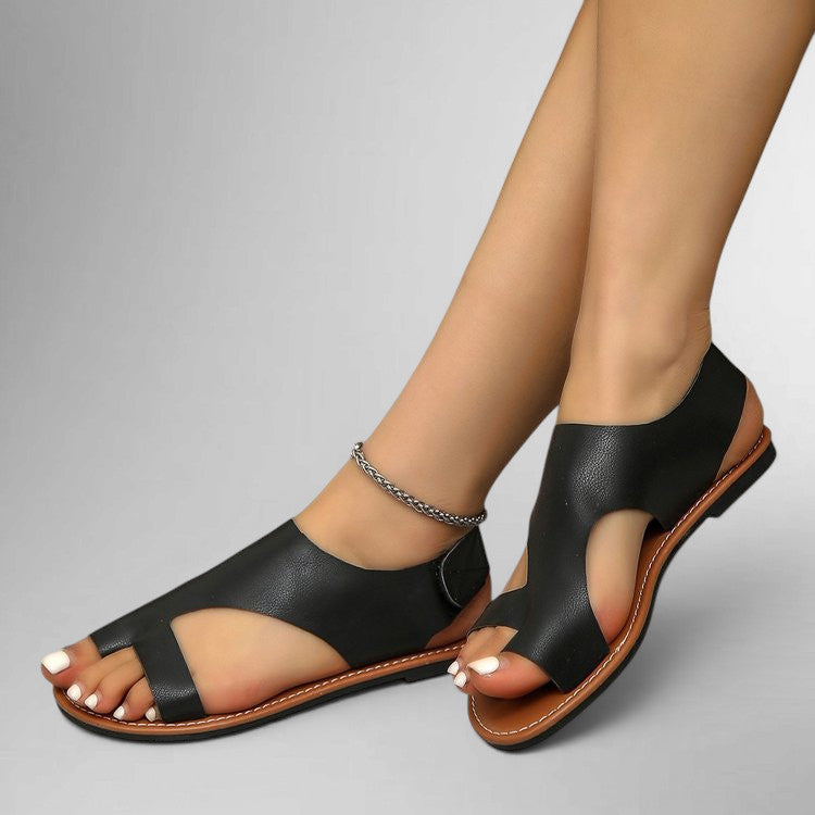 ZOFIA ATELIER black leather flat sandals with velcro toe strap and open heel. Comfortable and chic for everyday wear.