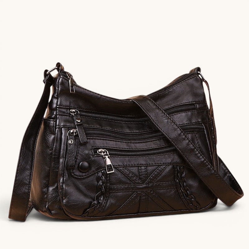 ZOFIA ATELIER black PU leather messenger bag with multiple zippered pockets and braided detail. Versatile for daily use.