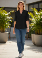 ZOFIA ATELIER black short-sleeve notch neck summer blouse on a woman wearing jeans.