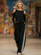 ZOFIA ATELIER black off-shoulder long sleeve top with white stripes and wide-leg pants with white stripes.
