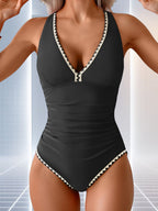 ZOFIA ATELIER black one-piece swimsuit with V-neck, ruched sides, and contrast trim. Halter neck.