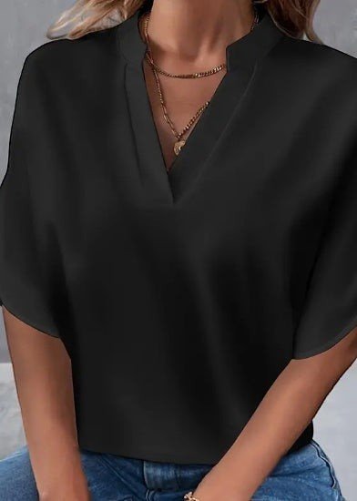 ZOFIA ATELIER black polyester notch neck blouse with short split sleeves and layered gold necklaces.