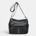 ZOFIA ATELIER GRAŻYNA multi-layer crossbody bag in black PU leather with braided detail and silver studs.