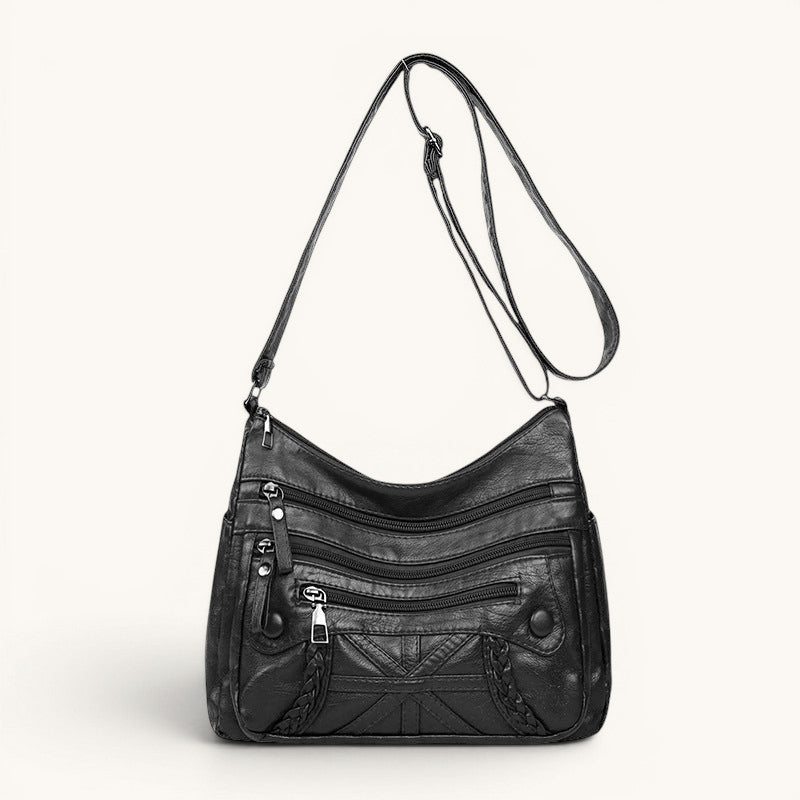 ZOFIA ATELIER black PU leather messenger bag with multiple zippered pockets and braided detail.