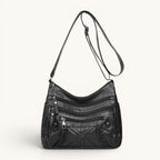 ZOFIA ATELIER black PU leather messenger bag with multiple zippered pockets and braided detail.