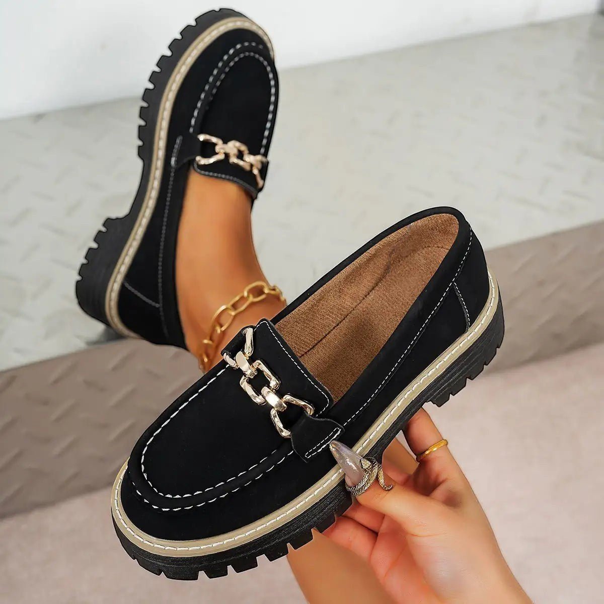 ZOFIA ATELIER black suede chunky platform loafers with gold chain detail and white stitching.