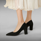 ZOFIA ATELIER black suede pointed toe pumps with a chunky heel and a sheer white skirt.