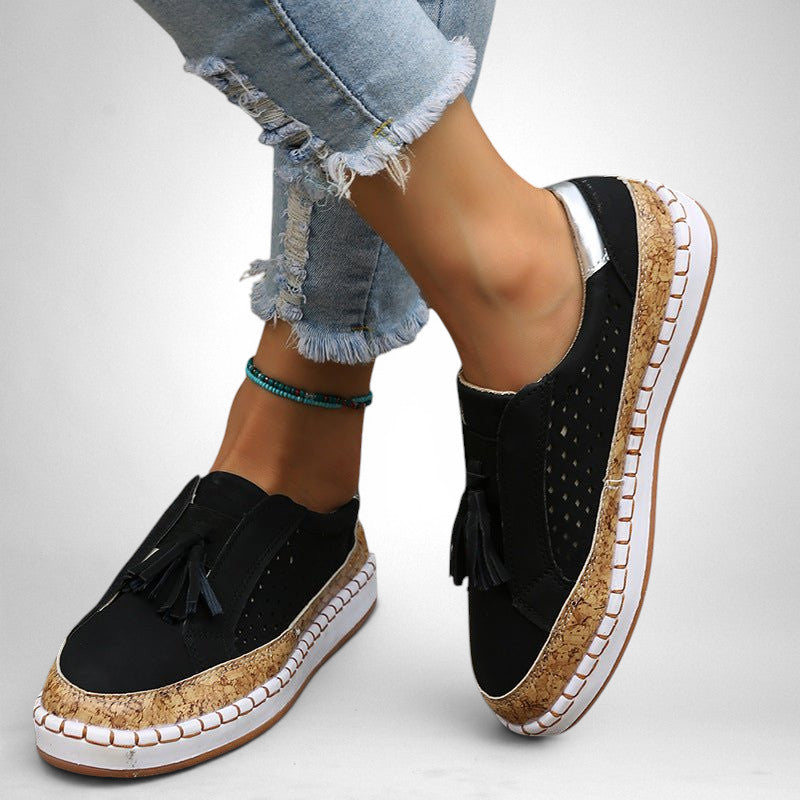 ZOFIA ATELIER black artificial PU tassel round toe flats with cork-effect sole and perforated details.