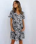 ZOFIA ATELIER black and white floral print mini dress with V-neck, short sleeves, and pockets.