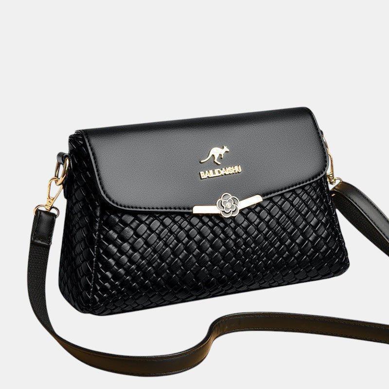 ZOFIA ATELIER black PU leather crossbody bag with woven texture and gold flower clasp.
