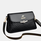 ZOFIA ATELIER black PU leather crossbody bag with woven texture and gold flower clasp.