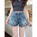 ZOFIA ATELIER blue denim shorts with embroidered flowers and scalloped hem. Mid-rise waist.