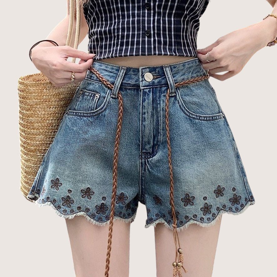 ZOFIA ATELIER blue denim shorts with embroidered flowers and frayed hem. Mid-rise waist, straight leg.