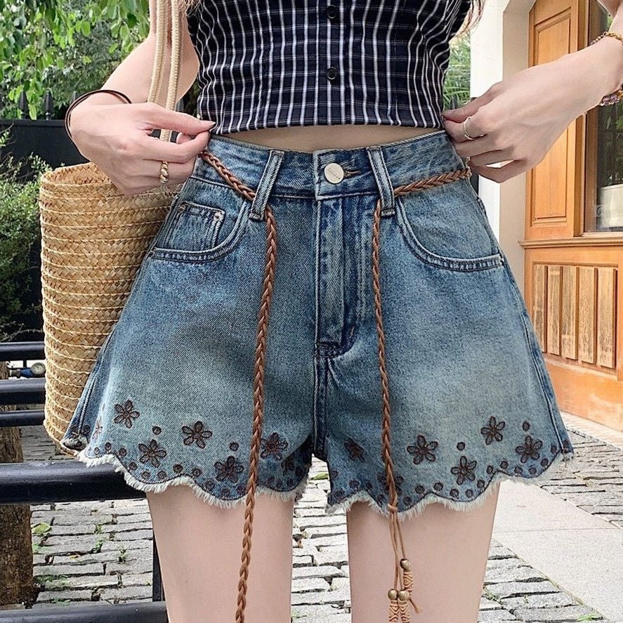ZOFIA ATELIER blue denim shorts with embroidered flowers and frayed hem. Mid-rise waist with braided belt.
