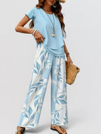 ZOFIA ATELIER light blue polyester top and wide-leg pants set with a blue and white leaf print.