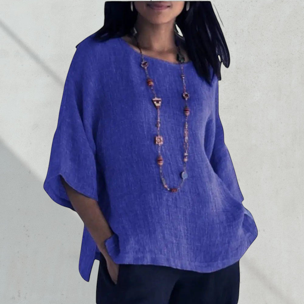 ZOFIA ATELIER blue linen blend relaxed fit blouse with short sleeves and a beaded necklace.