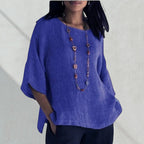 ZOFIA ATELIER blue linen blend relaxed fit blouse with short sleeves and a beaded necklace.