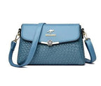 ZOFIA ATELIER blue PU leather crossbody bag with rhombus pattern and silver flower clasp. Medium hardness, lined interior.