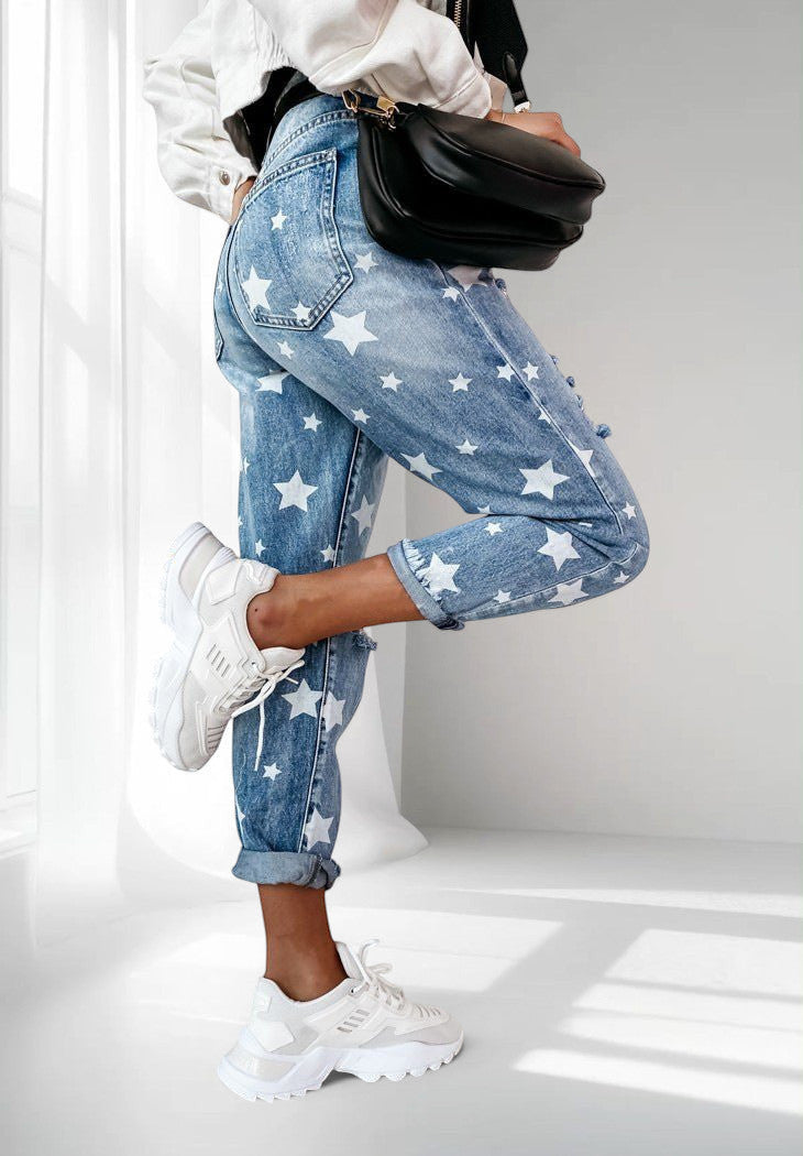 ZOFIA ATELIER blue denim trousers with white star print, slim fit, straight cut, and distressed details.