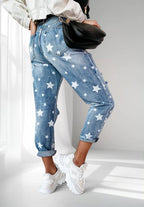 ZOFIA ATELIER blue denim trousers with white star print and distressed details, slim fit, cuffed hems.
