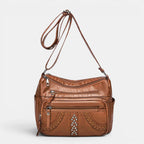 ZOFIA ATELIER GRAŻYNA multi-layer crossbody bag in brown PU leather with braided detail and silver studs.