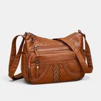 ZOFIA ATELIER brown PU leather crossbody bag with multi-layer design, braided accents, and stud embellishments.