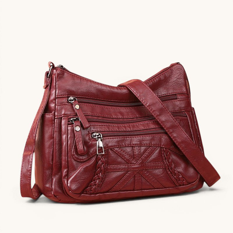ZOFIA ATELIER burgundy PU leather messenger bag with multiple zippered pockets and braided detail.