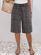 ZOFIA ATELIER calças capri pretas com padrão de bolinhas brancas, tecido leve, cintura subida, ajuste solto.