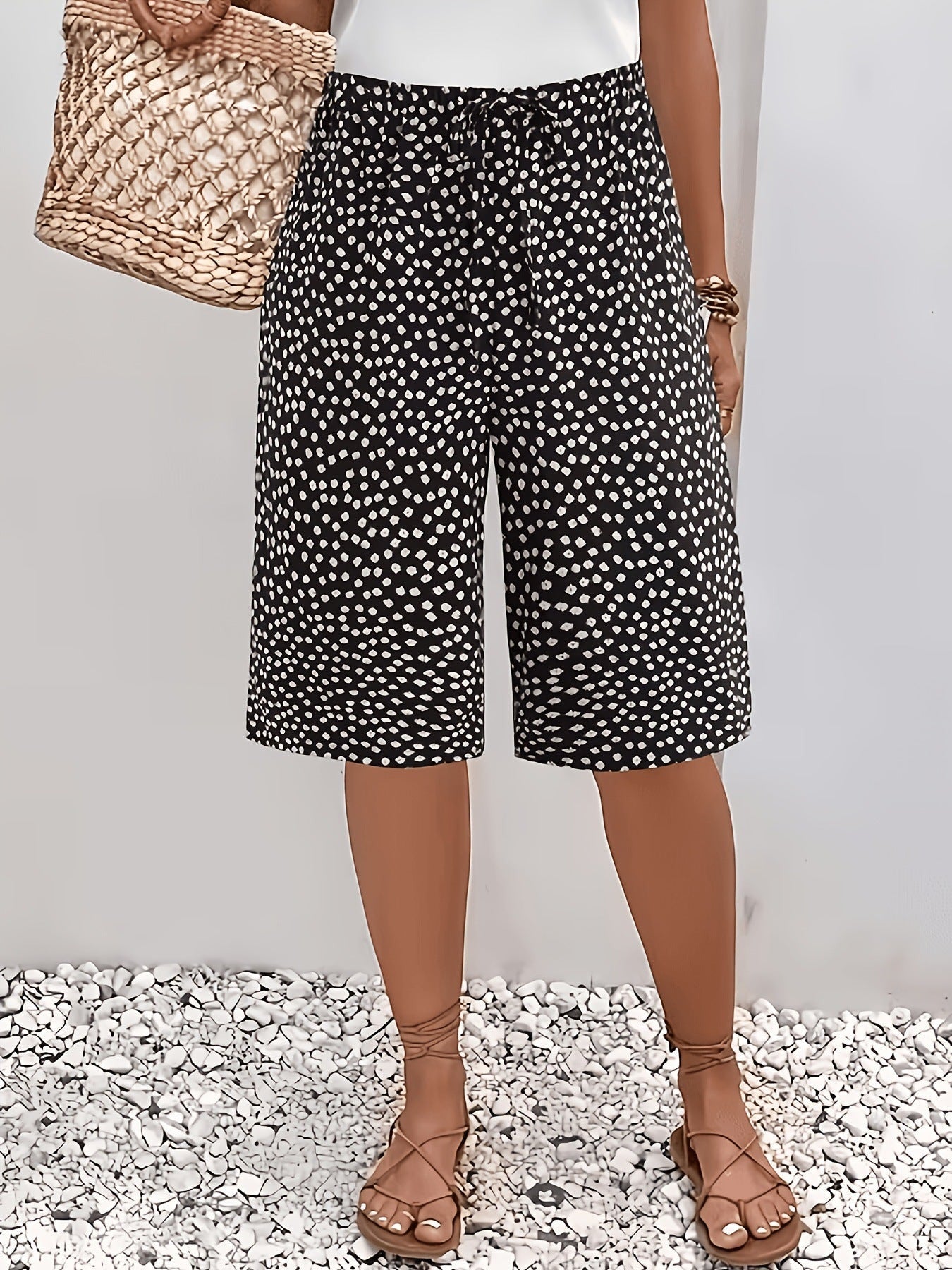 ZOFIA ATELIER calças capri pretas com padrão de bolinhas brancas, tecido leve, cintura subida, ajuste solto.