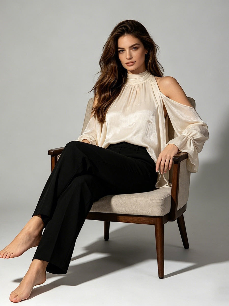 ZOFIA ATELIER cream cold-shoulder blouse with billowy sleeves and high halter neckline, paired with black trousers.