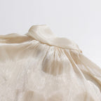 ZOFIA ATELIER cream cold-shoulder blouse with billowy sleeves and a high halter neckline. Flowy fabric.