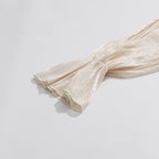 ZOFIA ATELIER cream cold-shoulder blouse with billowy sleeves and ruffled cuffs made of flowy, lightweight fabric.