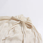 ZOFIA ATELIER cream cold-shoulder blouse with billowy sleeves and a tie detail.