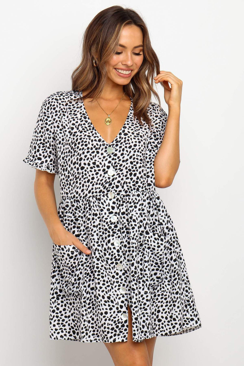 ZOFIA ATELIER black and white dalmatian print mini dress with V-neck, short sleeves, and button front. Loose waist and pockets.