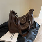 ZOFIA ATELIER dark brown PU leather dumpling shape tote bag with single strap and zipper closure.
