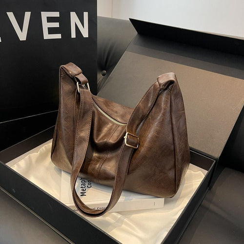 ZOFIA ATELIER dark brown PU leather dumpling shape tote bag with single strap and zipper closure.