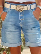 ZOFIA ATELIER light blue denim cropped shorts with a high waist, button fly, and rolled hem. Model wears a white belt.