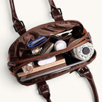 ZOFIA ATELIER Dominika brown leather messenger bag, open to show interior with books, umbrella, and cosmetics.