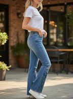 ZOFIA ATELIER blue denim jeans with embroidered butterflies and flowers on the leg.