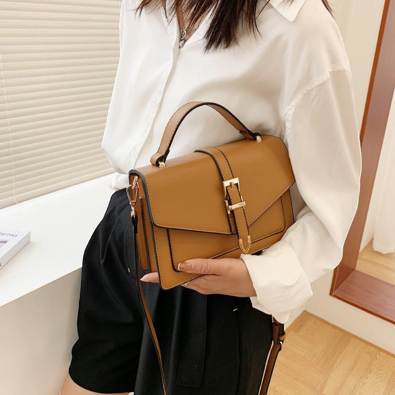 ZOFIA ATELIER Ewerina crossbody bag in brown PU leather with gold buckle detail. Structured, horizontal square shape with top handle and adjustable strap.