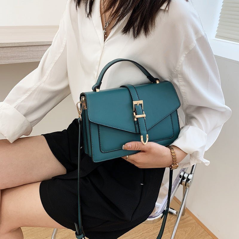 ZOFIA ATELIER Ewerina crossbody bag in teal PU leather with gold buckle detail. Features a top handle and adjustable strap.